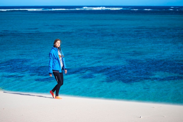 meisje loopt op zandduinen in Coral Bay met uitzicht op Ningaloo Reef, West-Australië