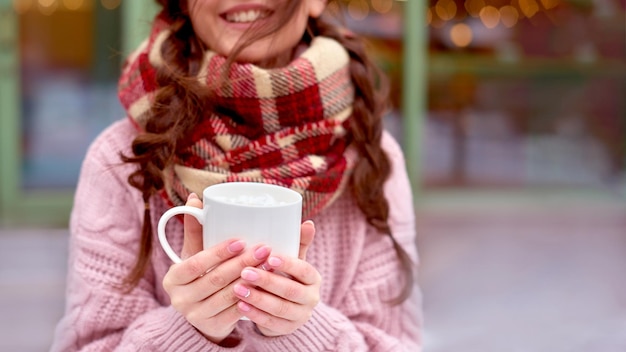 Meisje lopen met koffie op straat van wintervakantie stad en warme koffie drinken met marshmallow