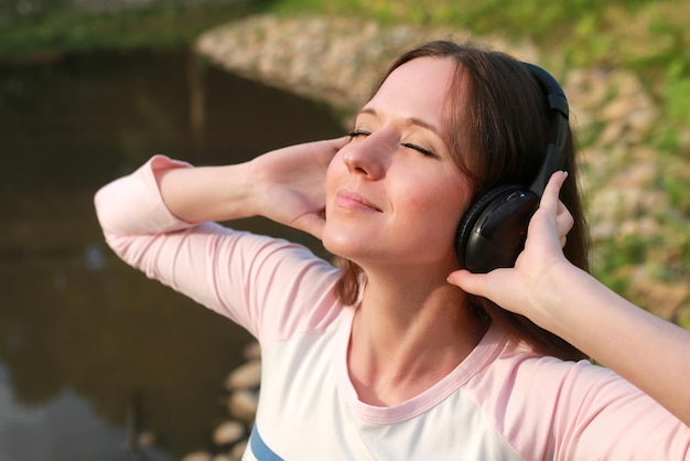 Meisje luister muziek in hoofdtelefoon buiten