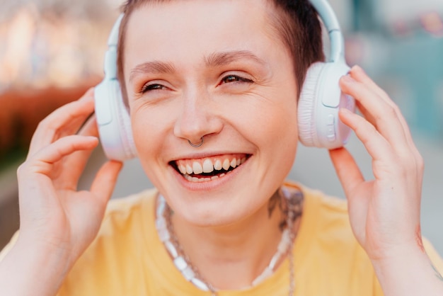 Meisje luistert naar muziek met witte koptelefoon glimlachend