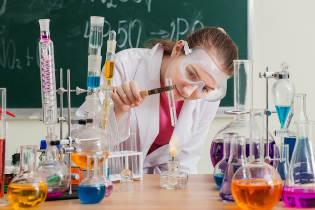 Meisje maakt een chemisch experiment in een scheikundeles