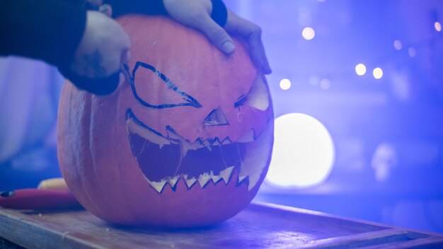 Foto meisje maakt een halloween-pompoen