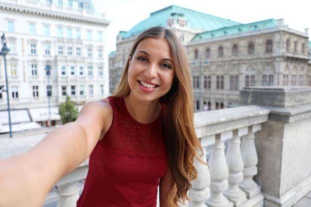 Meisje maakt zelfportret in Wenen met beroemde historische paleizen Staatsopera en Hotel Sacher, Oostenrijk