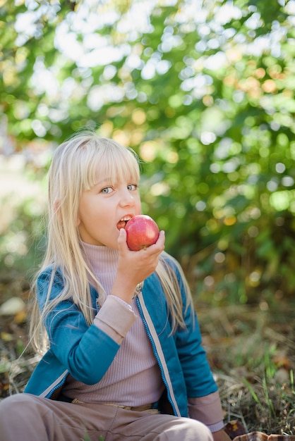 Meisje met appel in boomgaard. Oogstconcept.