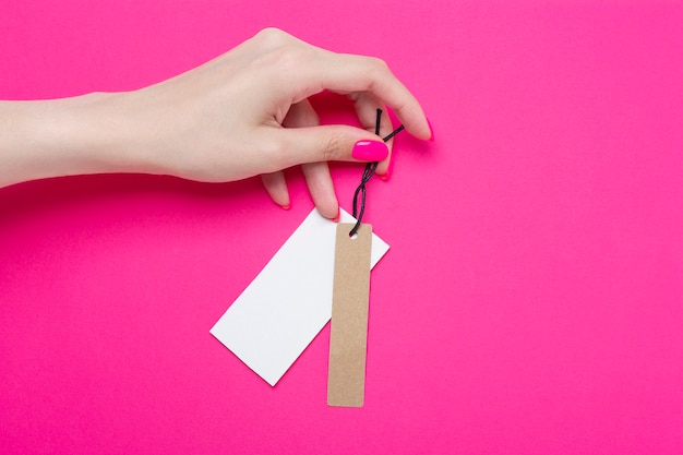 Meisje met badge met prijskaartje op roze papieren achtergrond