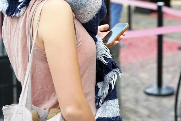 Meisje met behulp van slimme telefoon in de zomer van de stad