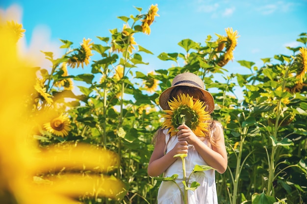 Meisje met bloem die op het veld staat.
