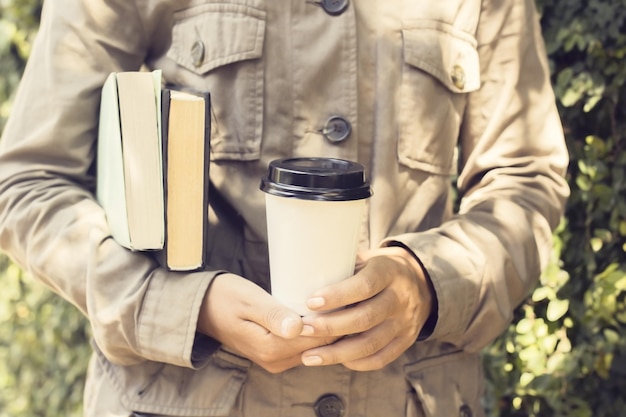 Meisje met boeken en koffie buiten