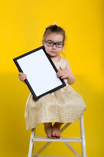 Meisje met bord in mooie jurk en glazen op gele achtergrond
