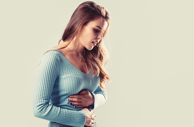 Meisje met buikpijn Jonge vrouw met buikpijn Vrouw Maagpijn