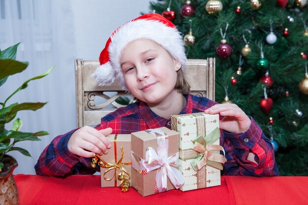 Meisje met cadeautjes op de achtergrond van de kerstboom