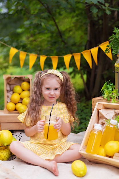 Meisje met citroenen en limonade buiten op picknick