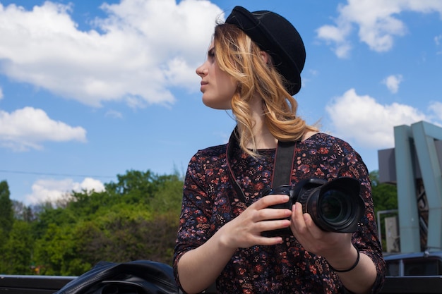 Meisje met de digitale camera en de lucht op de achtergrond