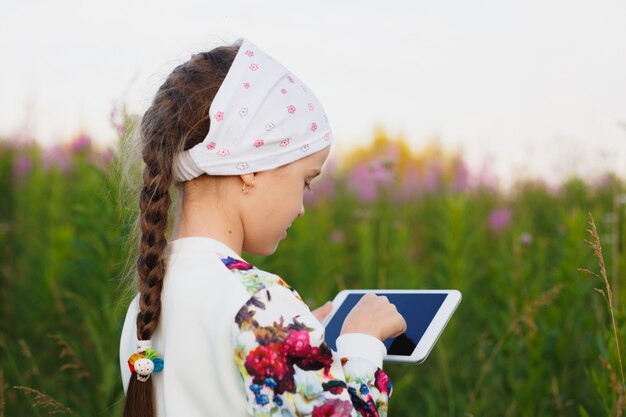 Foto meisje met digitale tablet op de aard