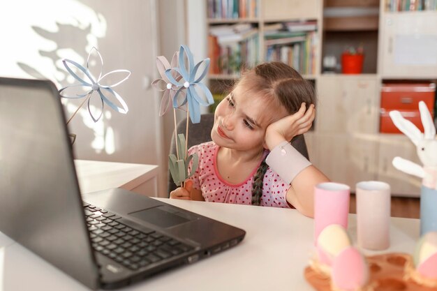 Meisje met DIY-bloemen die familie begroeten met online lentevakantie, eter, Moederdagviering