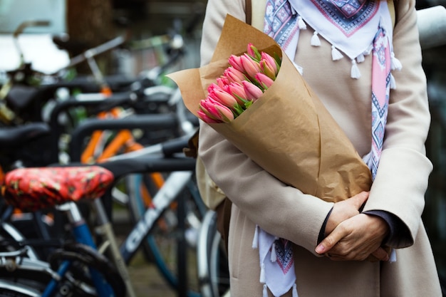 Meisje met een boeket tulpen in een straat in amsterdam