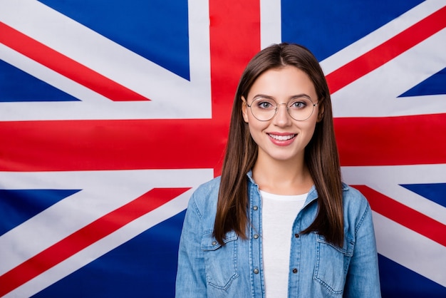 meisje met een bril op de Britse achtergrond van de strepenvlag