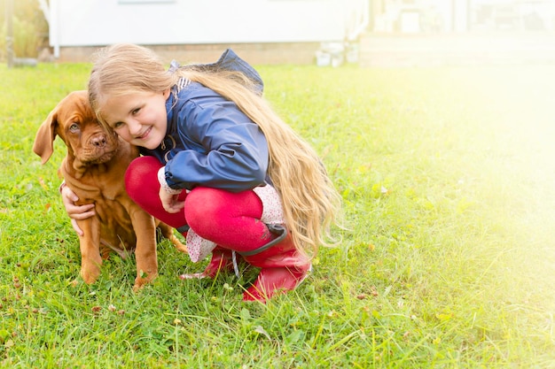 Meisje met een Dogue de Bordeaux-puppy Grote puppy