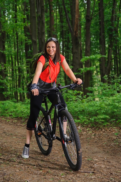 Meisje met een fiets in het bos