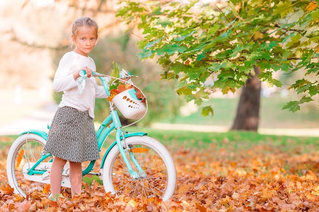 Meisje met een fiets op een mooie herfstdag buiten in het park