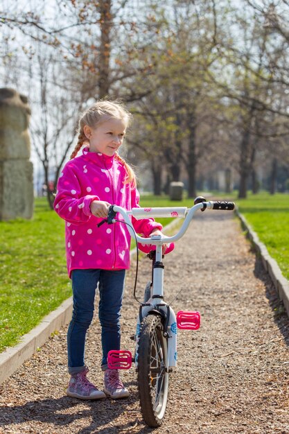 Meisje met een fiets op een wandeling in het park