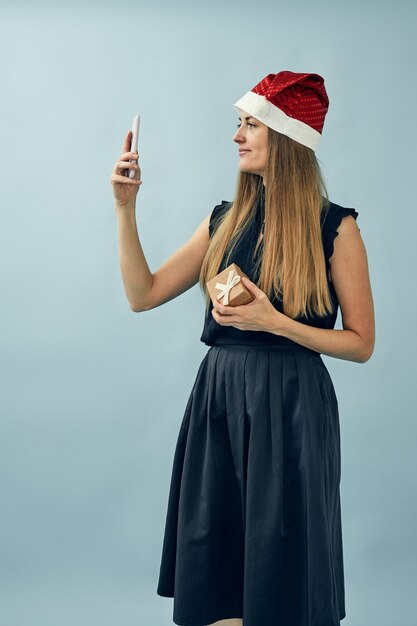 Meisje met een geschenkdoos in haar handen en het dragen van een kerstman hoed