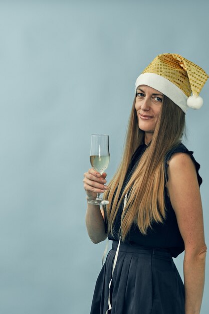 Meisje met een glas champagne en een hoed van de kerstman