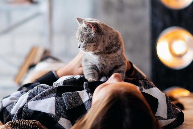 Meisje met een grijze Schotse kat in haar armen in de slaapkamer huisdier close-up