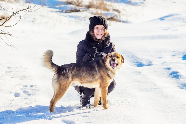 Meisje met een hond in de winter tijdens een wandeling. meisje en hond tegen de achtergrond van witte sneeuw