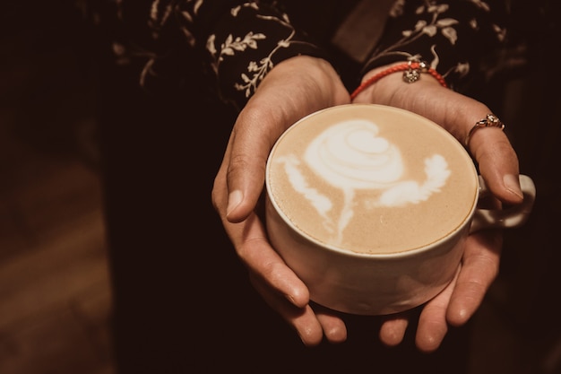 Meisje met een kopje cappuccino met roos