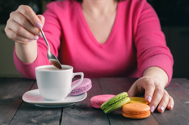 Meisje met een kopje koffie met macaron