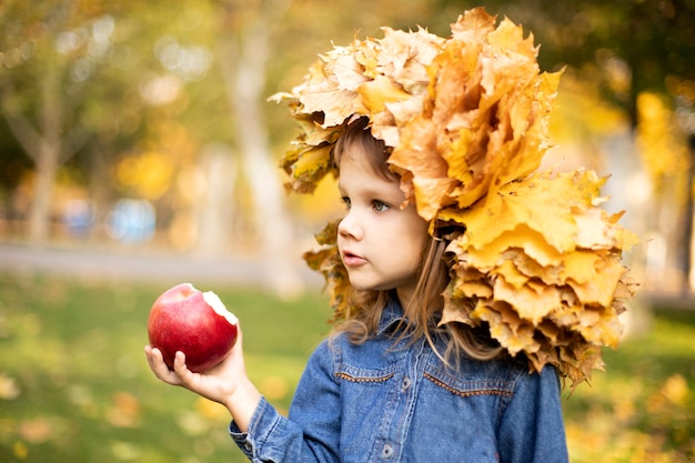Meisje met een krans van bladeren die appels eten
