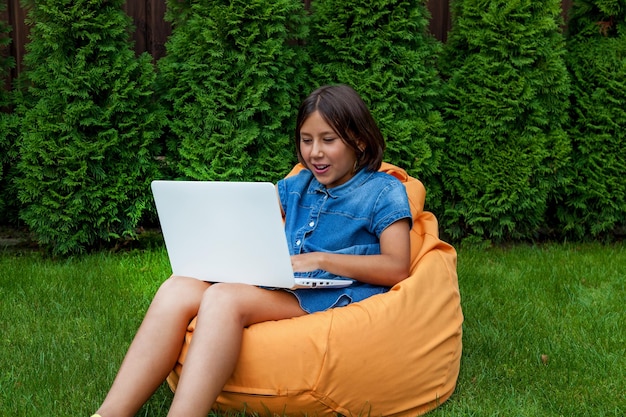 Meisje met een laptop in de tuin