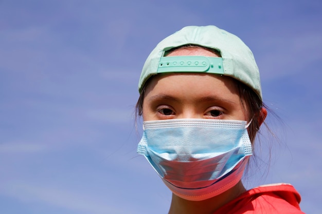 Meisje met een masker op haar gezicht op de achtergrond op een blauwe lucht