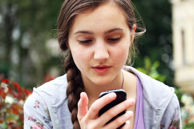 Meisje met een mobiele telefoon leest het bericht