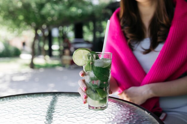 Meisje met een mojito in haar handen Mojito op een glazen tafel Zomer Heerlijke cocktail in de zomer Mojito in een glas