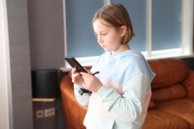 Meisje met een smartphone in de kamer