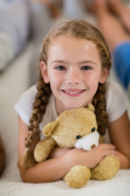 Meisje met een teddybeer op bed in de slaapkamer