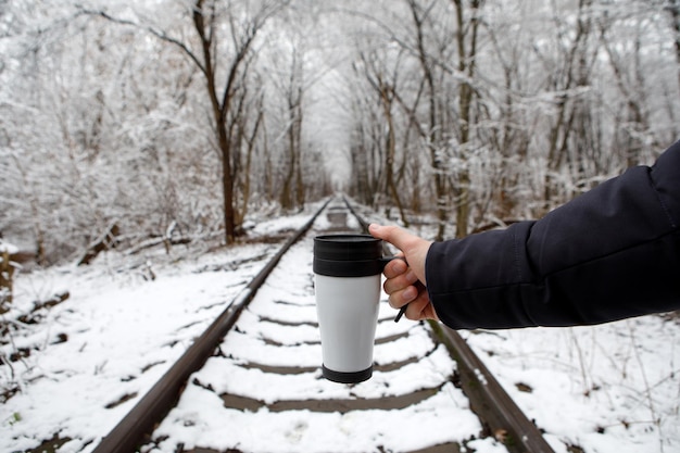 Meisje met een thermosbeker in de winter