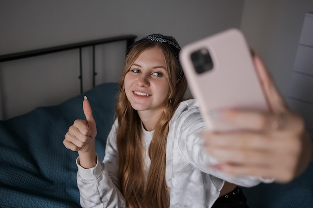 Meisje met een verband op haar hoofd en lang blond haar maakt een selfie