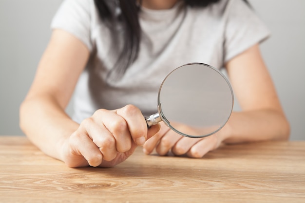 Meisje met een vergrootglas aan tafel