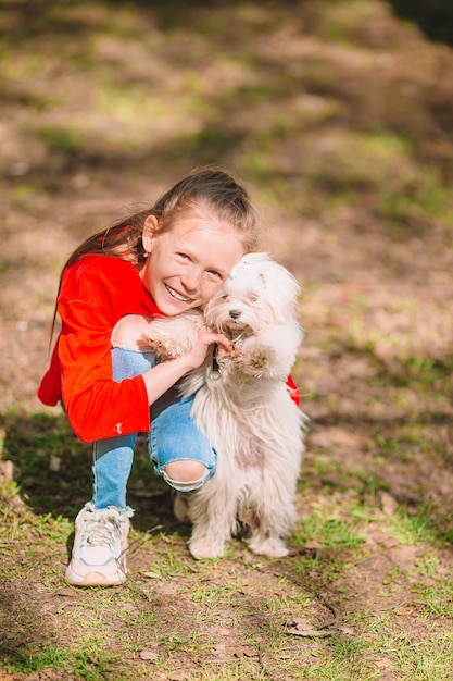 Meisje met een witte puppy. Een puppy in de handen van een meisje