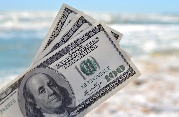 Meisje met geldrekening van 300 dollar op de achtergrond van de zee oceaan