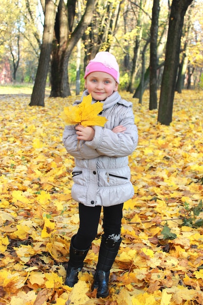 Meisje met gele bladeren die zich in het park bevinden