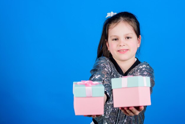 Meisje met geschenkdozen blauwe achtergrond Black friday Winkeldag Schattig kind draagt geschenkdozen Verrassingsgeschenkdoos Verjaardagsverlanglijstje Wereld van geluk Elke dag gebeurt er iets speciaals Kies er een