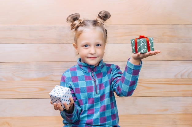 Meisje met geschenken in handen op de achtergrond van houten planken.