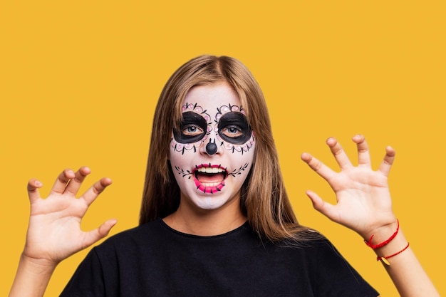 Meisje met geschilderd gezicht kijkend naar camera in studio en klaar om te feesten