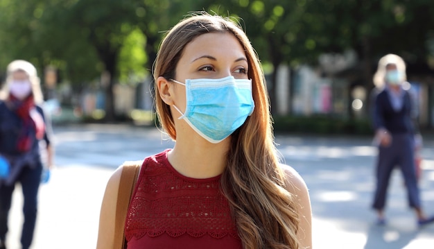Meisje met gezichtsmasker loopt met respect voor sociale afstand tijdens Pandemic Coronavirus Disease 2019.