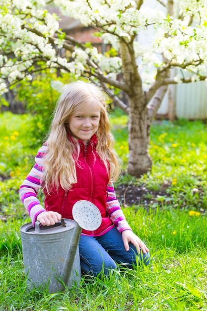 Meisje met gieter in de tuin, lente