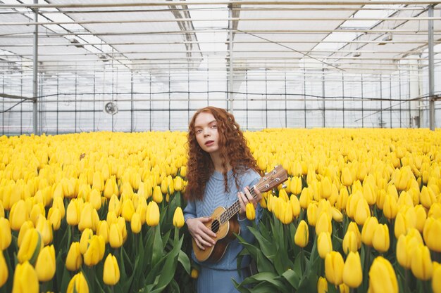 Meisje met gitaar op zoek camera